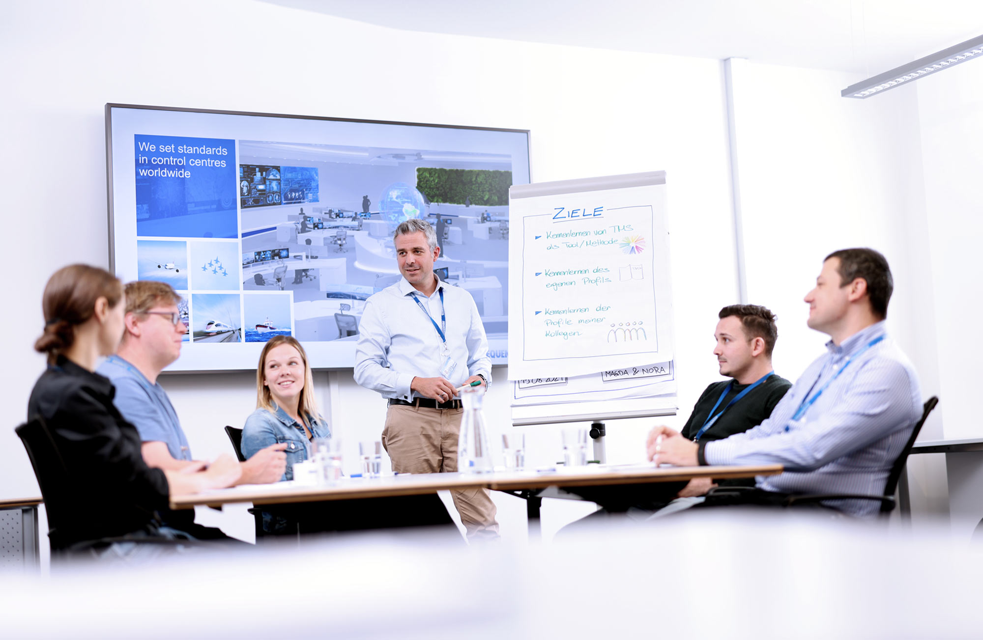 header picture showing employees working at Frequentis, in a meeting room
