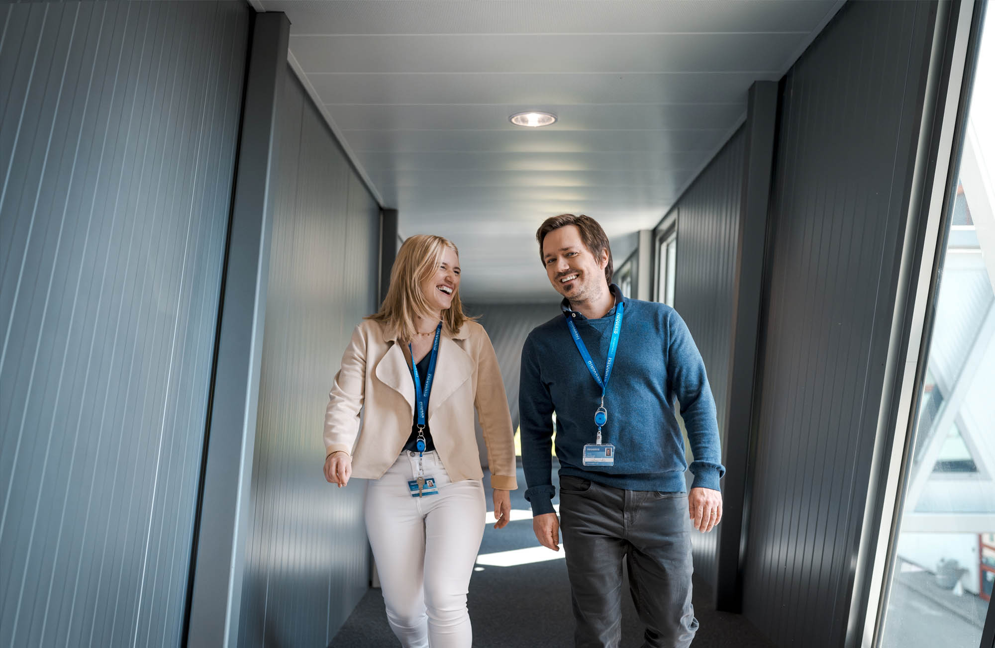 Frequentis Employer Branding header picture, showing two employees in the hallway