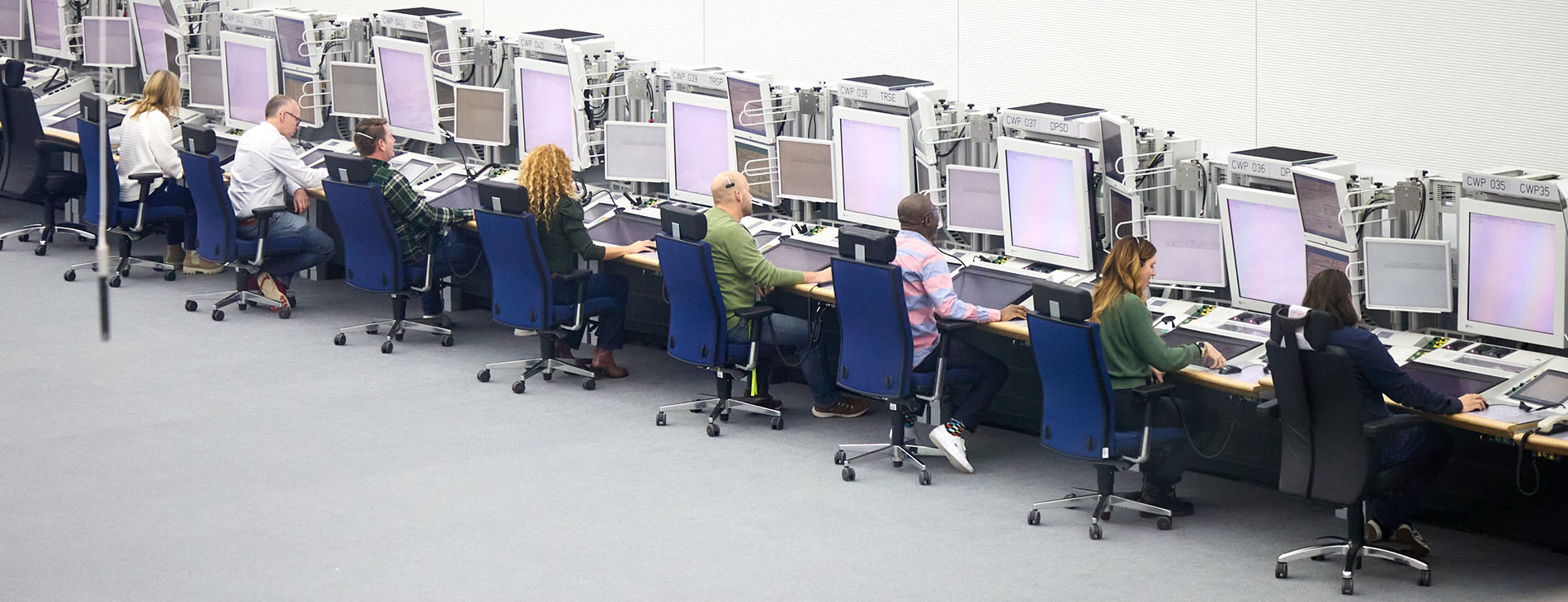 Blick in die DFS Kontrollzentrale München; 8 Fluglots:innen an ihren Arbeitsplätzen